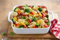 Baked vegetable and sausages lumaconi pasta in white baking dish