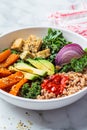 Baked vegetables, avocado, tofu and buckwheat buddha bowl. Vegan lunch salad with kale, baked sweet potato, tofu, buckwheat and Royalty Free Stock Photo