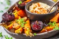 Baked vegetables with hummus in a dark dish Royalty Free Stock Photo