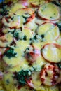 Baked vegetables with meat and potatoes, sprinkled with cheese