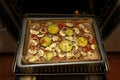 Baked vegetables with Mediterranean herbs and spices on the tray fresh from the dark oven, vegetarian meal, selected focus Royalty Free Stock Photo