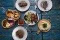 Baked vegetables and steaks served on blue shabby table - cozy homemade food .