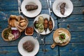 Baked vegetables and steaks served on blue shabby table - cozy homemade food .