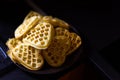 Baked Viennese waffles in the shape of hearts lying slides on a plate