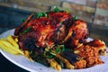 Baked whole chicken with oranges and potatoes on a plate. horizontal view from above Royalty Free Stock Photo