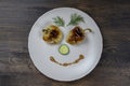 Baked yellow pepper, cucumber, green dill and french old-fashioned dijon mustard on a plate in the shape of a happy face, top view