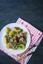 Baked young potatoes with meat and vegetables. Dark wooden background Royalty Free Stock Photo