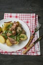 Baked young potatoes with meat and vegetables. Dark wooden background Royalty Free Stock Photo