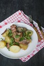 Baked young potatoes with meat and vegetables. Dark wooden background Royalty Free Stock Photo