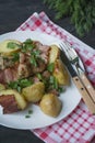 Baked young potatoes with meat and vegetables. Dark wooden background Royalty Free Stock Photo