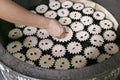 Baker Adding Raisins on the Batter of Portuguese-Siamese Kudeejeen Cupcakes or Khanom Farang Kudeejeen