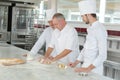 Baker and assistants in bakery kitchen