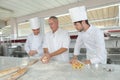Baker and assistants in kitchen bakery Royalty Free Stock Photo