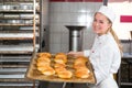 Baker in bakehouse or bakery posing with tray of fresh bread Royalty Free Stock Photo