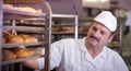 baker in a bakery getting fresh bread out of oven Royalty Free Stock Photo