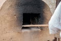 Baker bakes bread in an clay oven