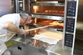 Baker bakes bread in oven