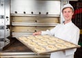 Baker with baking plate full of pretzels