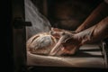 A baker baking traditional, healthy bread in a large oven. Healthy real bread produced using the traditional method.