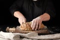 baker in black uniform cuts a knife into slices of rye bread Royalty Free Stock Photo