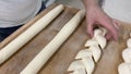 Baker cutting flour dough to make loaf of bread. Baker making bread. Artisan baker making bread. Royalty Free Stock Photo