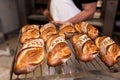 Baker with bread on wooden shovel coming out of the over in bakery shop. bread bakery concept with warm colors and wood peel Royalty Free Stock Photo