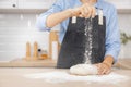 Baker chef hand sprinkling flour fresh dough on kitchen table, white background banner Royalty Free Stock Photo