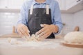 Baker chef hand sprinkling flour fresh dough on kitchen table, white background banner Royalty Free Stock Photo