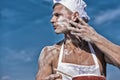 Baker concept. Cook or chef with sexy muscular shoulders and chest covered with flour. Chef cook preparing dough for Royalty Free Stock Photo