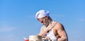 Baker concept. Man on busy face wears cooking hat and apron, sky on background. Chef cook preparing dough for baking Royalty Free Stock Photo