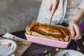 The baker cuts a banana cake. Close-up view girls hands with knife