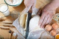 Baker cuts the dough with a knife bread, pizza or pie recipe ingredients with hands, food on kitchen table background, working wit Royalty Free Stock Photo