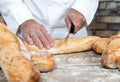Baker cutting traditional bread french baguettes Royalty Free Stock Photo