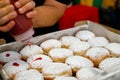 A baker decorates Hanukkah donuts with jam in a bakery