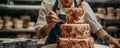 A baker decorating a cake with intricate designs inspired by mythology, featuring mythical beasts and Royalty Free Stock Photo