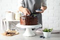 Baker decorating fresh delicious homemade chocolate cake with berries on table Royalty Free Stock Photo