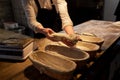 Baker with dough rising in baskets at bakery Royalty Free Stock Photo