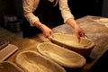 Baker with dough rising in baskets at bakery Royalty Free Stock Photo