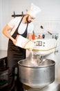 Baker filling flour into the kneader Royalty Free Stock Photo