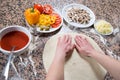 Baker Flattening Dough With Hands And Preparing It For Making Vegetarian Pizza On Marble Table Royalty Free Stock Photo