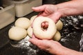 Baker forming bagels from dough