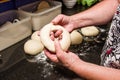 Baker forming bagels from dough