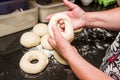 Baker forming bagels from dough