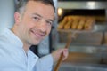 Baker getting fresh bread out traditional oven Royalty Free Stock Photo