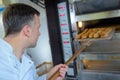 Baker getting fresh bread out traditional oven Royalty Free Stock Photo
