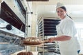 Baker getting fresh bread with shovel out of oven Royalty Free Stock Photo