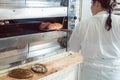 Baker getting fresh bread with shovel out of oven Royalty Free Stock Photo