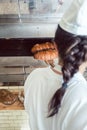 Baker getting fresh bread with shovel out of oven Royalty Free Stock Photo