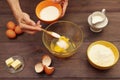 Baker hands pour sugar into a bowl for making dough on rustic table Royalty Free Stock Photo