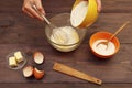 Baker hands pouring flour into a bowl for making dough on wooden table Royalty Free Stock Photo